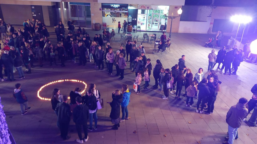 Grup de persones davant l'Ajuntament amb un cercle de espelmes enceses