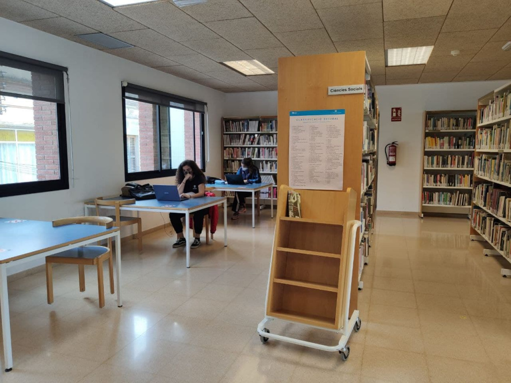 Estudiants al segon pis de la biblioteca amb els seus portàtils