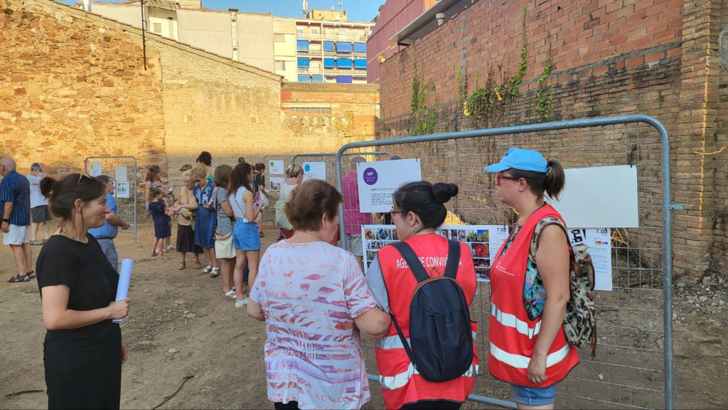 Agents Cívics explicant en els panell a una senyora el nou espai públic