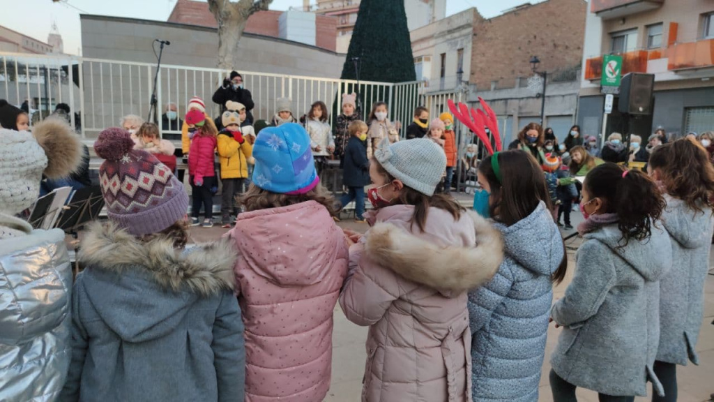 Alumnes de l'Escola de música preparats per cantar a l'escenari de la plaça de l'Ajuntament