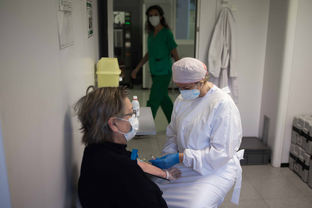 Infermera del Cap amb mesures de protecció i prevenció posant la vacuna a una senyora gran