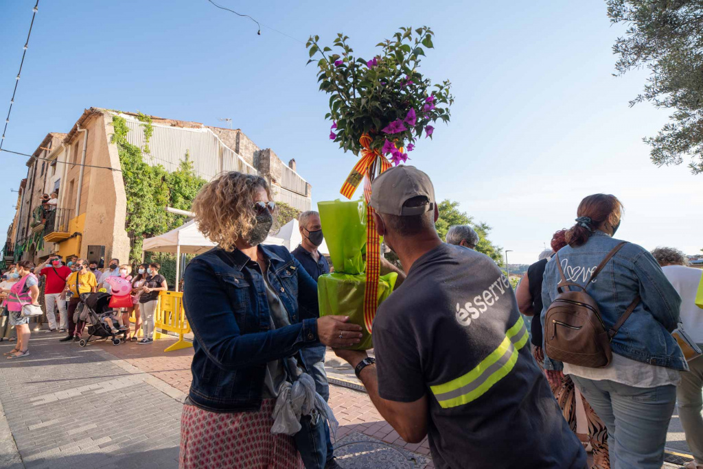 Ofrena floral d'una senyora ajudada per un operari