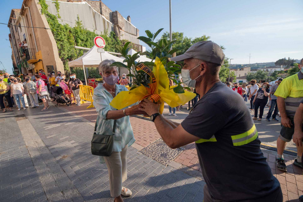 Ofrena flora d'una senyora ajudada per un operari