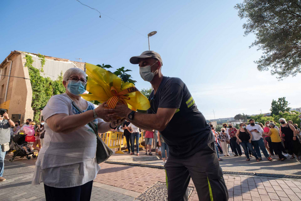 Ofrena d'una senyora ajudada per un operari de l'ajuntament