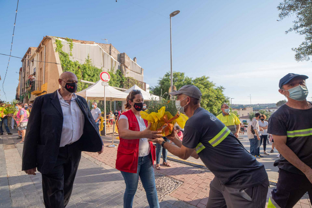 Ofrena d'una senyora a Santa Oliva ajudada per dos operaris